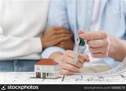 embraced defocused couple holding keys their new house. Resolution and high quality beautiful photo. embraced defocused couple holding keys their new house. High quality beautiful photo concept