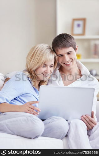 Embracing couple is looking into the laptop at home