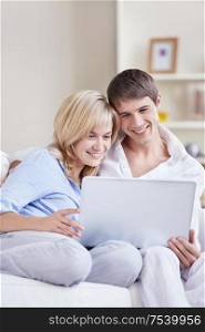Embracing couple is looking into the laptop at home