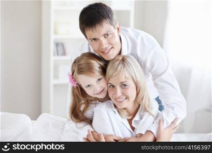 Embracing family of three at home