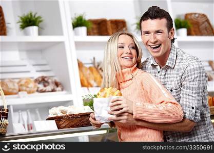Embracing young couple in a baker&acute;s shop