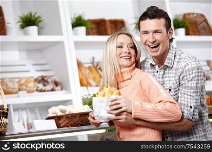 Embracing young couple in a baker?s shop