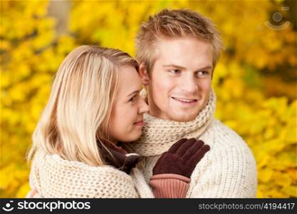 Embracing young couple in love in autumn park