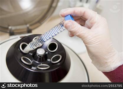 Embryologist putting sample into centrifuge (selective focus)