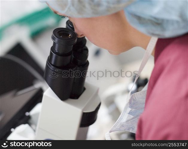 Embryologist with microscope performing an intra cytoplasmic sperm injection (selective focus)