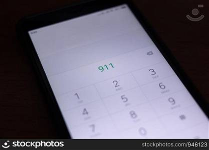 Emergency and urgency, dialing 911 on smartphone screen.