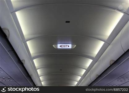 emergency exit sign on the ceiling of airplane