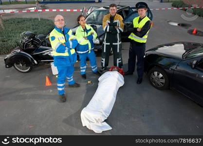 Emergency Medical Services team posing over an injured driver at the scene of a car crash