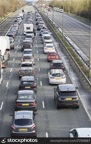 Emergency services closing motorway to attend accident causing a traffic jam