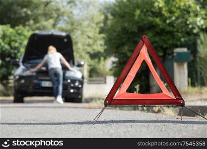 emergency stop sign and broken car on the road