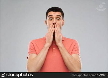 emotion, advertisement and people concept - scared man in polo t-shirt over gray background