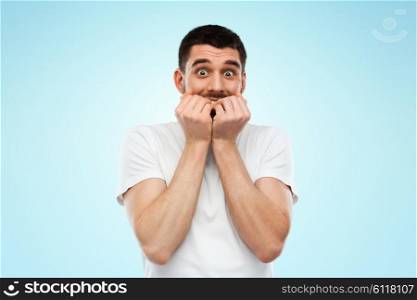 emotion, advertisement and people concept - scared man in white t-shirt over blue background