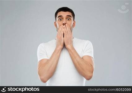 emotion, advertisement and people concept - scared man in white t-shirt over gray background