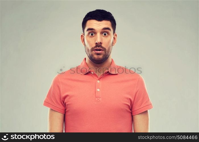 emotion, advertisement and people concept - surprised man in polo t-shirt over gray background. surprised man in polo t-shirt over gray background. surprised man in polo t-shirt over gray background