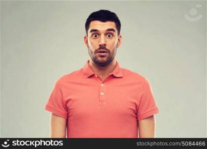 emotion, advertisement and people concept - surprised man in polo t-shirt over gray background. surprised man in polo t-shirt over gray background. surprised man in polo t-shirt over gray background
