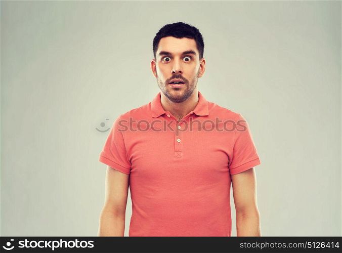 emotion, advertisement and people concept - surprised man in polo t-shirt over gray background. surprised man in polo t-shirt over gray background