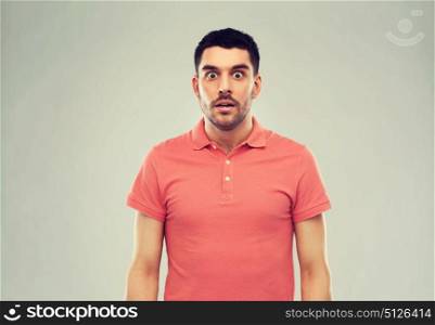 emotion, advertisement and people concept - surprised man in polo t-shirt over gray background. surprised man in polo t-shirt over gray background