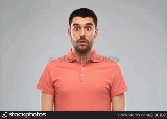 emotion, advertisement and people concept - surprised man in polo t-shirt over gray background
