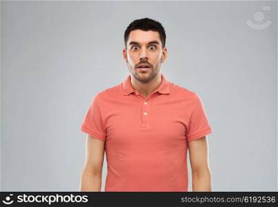 emotion, advertisement and people concept - surprised man in polo t-shirt over gray background