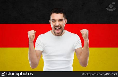 emotion, aggression, gesture and people concept - angry young man or immigrant showing fists over german flag background