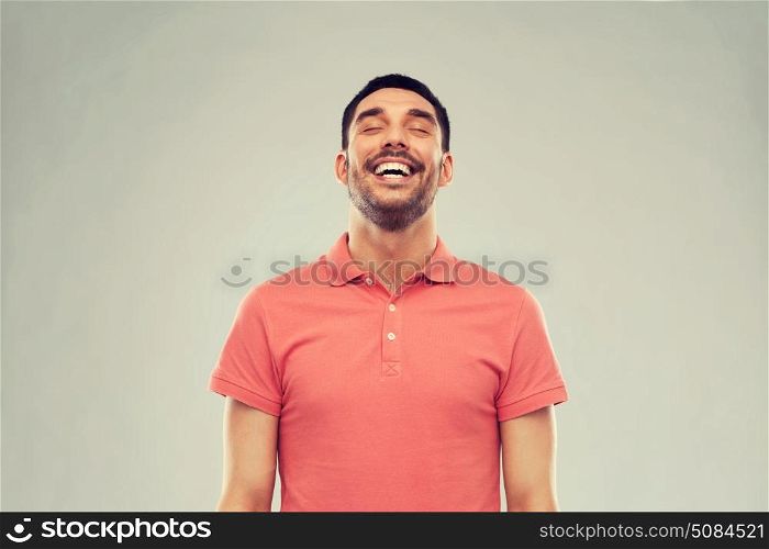 emotion and people concept - laughing man in polo t-shirt over gray background. laughing man over gray background. laughing man over gray background