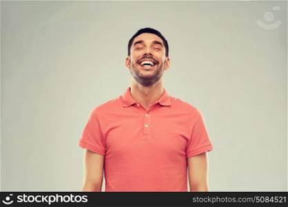 emotion and people concept - laughing man in polo t-shirt over gray background. laughing man over gray background. laughing man over gray background