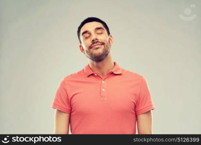 emotion and people concept - laughing man in polo t-shirt over gray background. laughing man over gray background