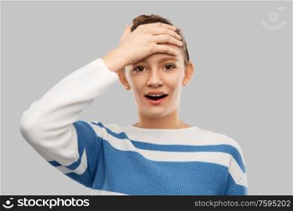 emotion and people concept - surprised teenage girl in pullover over grey background. surprised teenage girl in pullover