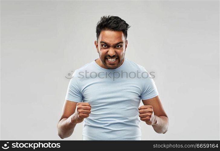 emotion, anger and people concept - angry indian man screaming over grey background. angry indian man screaming over grey background