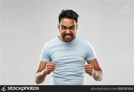 emotion, anger and people concept - angry indian man screaming over grey background. angry indian man screaming over grey background