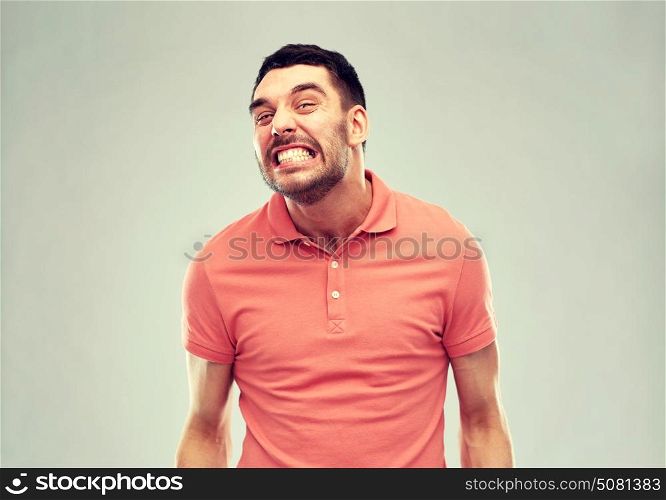 emotion, cruelty, anger and people concept - angry man over gray background. angry man over gray background
