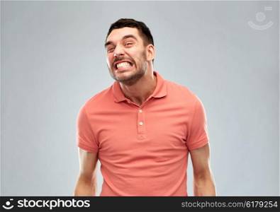 emotion, cruelty, anger and people concept - angry man over gray background