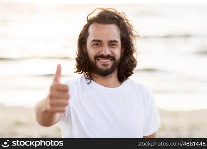 emotion, expression and people concept - happy smiling man with beard on beach