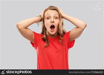 emotion, expression and people concept - impressed or shocked teenage girl with open mouth in red t-shirt over grey background. impressed or shocked teenage girl in red t-shirt