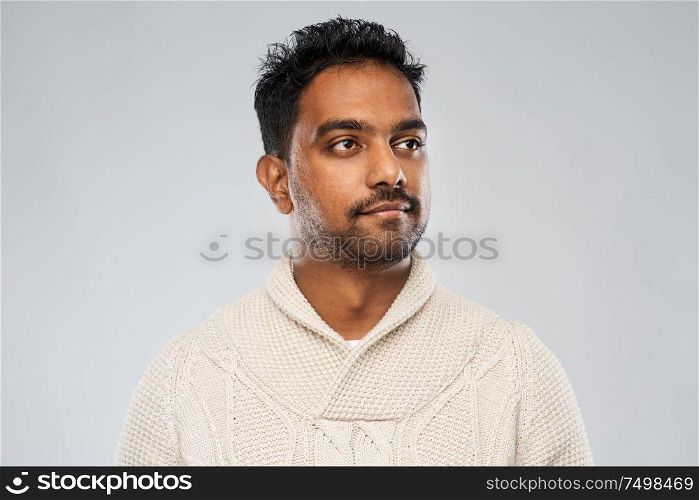 emotion, expression and people concept - indian man in knitted woollen sweater over gray background. indian man in knitted sweater over gray background