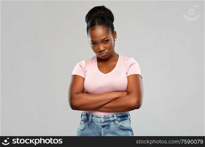 emotion, expression and people concept - sad african american woman with crossed arms over grey background. sad african american woman with crossed arms