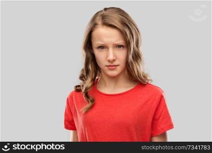 emotion, expression and people concept - sad or angry teenage girl in red t-shirt over grey background. sad or angry teenage girl in red t-shirt