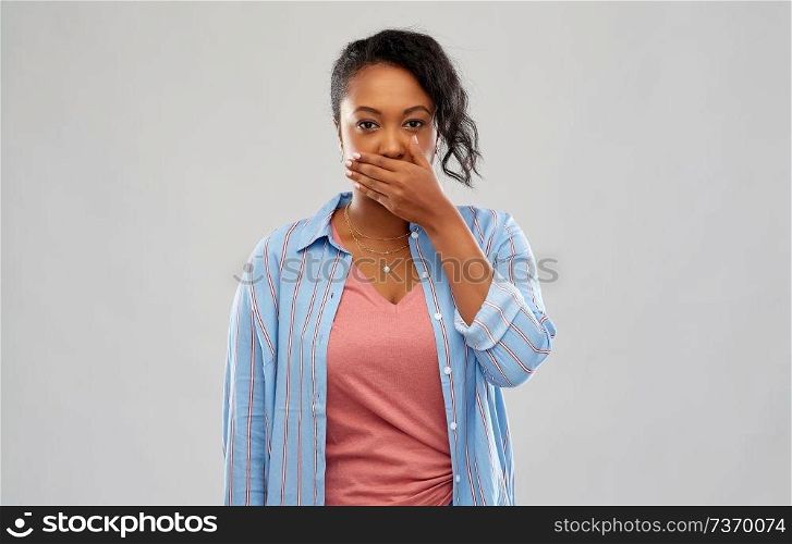 emotion, expression and people concept - shocked african american woman over grey background. shocked african american woman covering her mouth