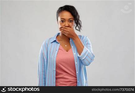 emotion, expression and people concept - shocked african american woman over grey background. shocked african american woman covering her mouth