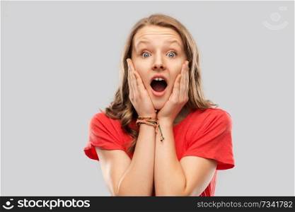 emotion, expression and people concept - shocked or scared teenage girl with open mouth in red t-shirt over grey background. shocked or scared teenage girl in red t-shirt
