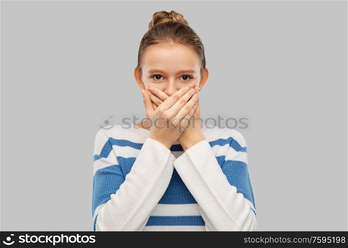 emotion, expression and people concept - teenage girl covering mouth by hands over grey background. teenage girl covering mouth by hands