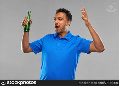 emotion, expression and success concept - emotional indian man or sports fan beer bottle over grey background. emotional indian man or sports fan beer bottle