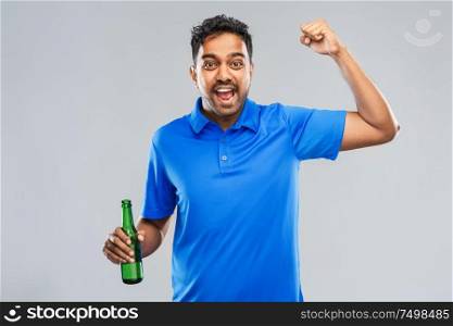 emotion, expression and success concept - happy indian man or sports fan beer bottle celebrating victory over grey background. male fan with beer bottle celebrating victory