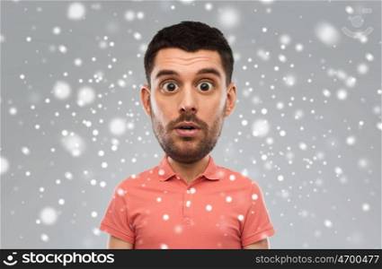 emotion, facial expression, winter, christmas and people concept - surprised man in polo shirt (funny cartoon style character with big head) over snow on gray background