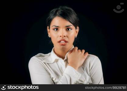 Emotion Fear. Face of a beautiful fearful young woman, expressing fear, studio portrait, black background