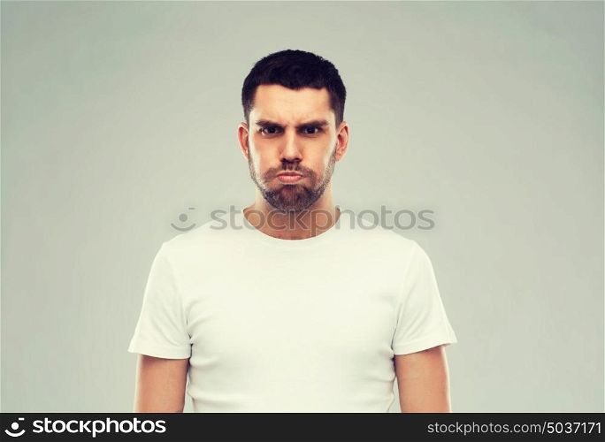 emotion, fun and people concept - man with funny angry face over gray background. man with funny angry face over gray background