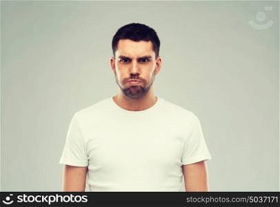 emotion, fun and people concept - man with funny angry face over gray background. man with funny angry face over gray background