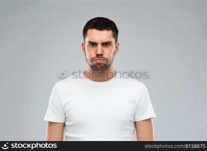 emotion, fun and people concept - man with funny angry face over gray background
