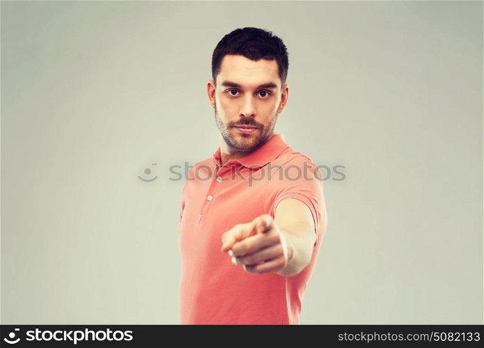 emotion, gesture and people concept - angry man pointing finger to you over gray background. angry man pointing finger to you over gray