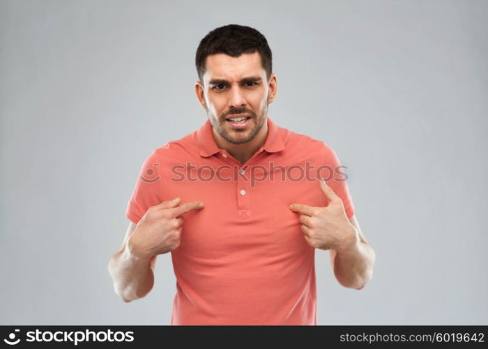 emotion, gesture, argue and people concept - arguing angry man pointing finger to himself over gray